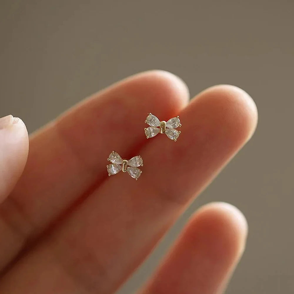 أقراط مرصعة بحجر الزركونيا المكعب المستدير على شكل قضيب معدني ذهبي اللون للنساء، بتصميم عقدة فيونكة، أقراط كلاسيكية براقة.