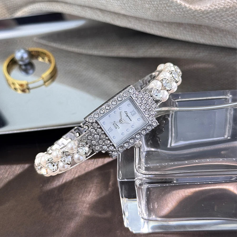 ساعة يد نسائية فاخرة بتصميم فرنسي رومانسي، مرصعة بصفين من اللؤلؤ الصغير، وسوار مربع مرصع بالألماس، تعمل بنظام الكوارتز.